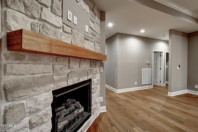 unfurnished living room with hardwood / wood-style flooring and a stone fireplace