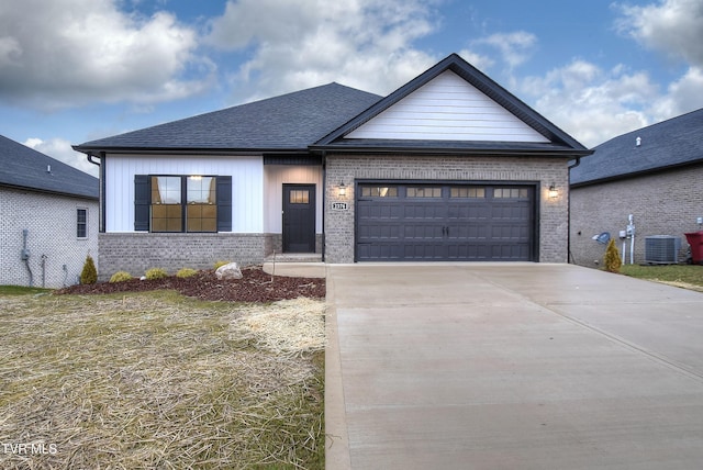 view of front facade with a garage and central air condition unit