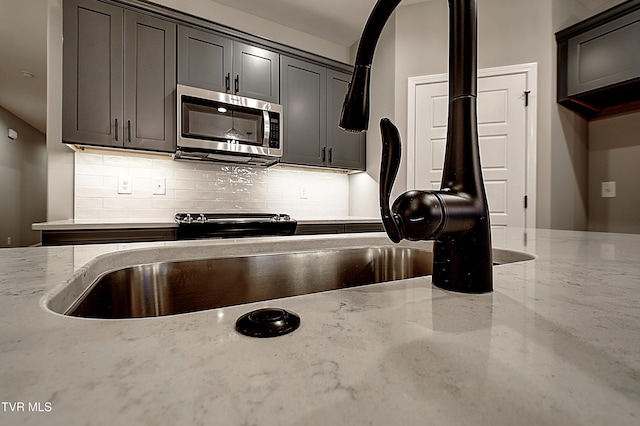 kitchen featuring tasteful backsplash and light stone counters