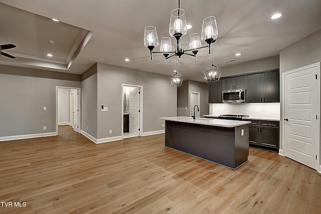 kitchen featuring light hardwood / wood-style floors, an island with sink, and hanging light fixtures