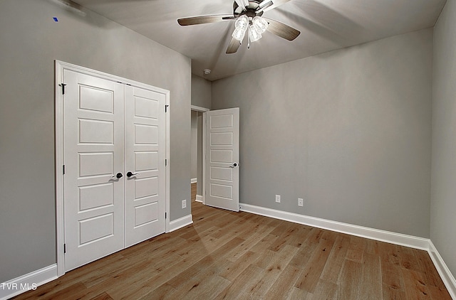 unfurnished bedroom with ceiling fan, light hardwood / wood-style floors, and a closet