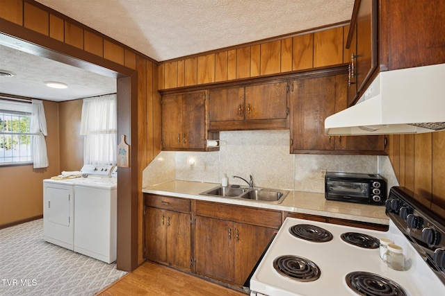 kitchen featuring white electric range oven, washer and clothes dryer, sink, and a textured ceiling