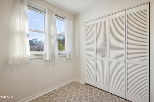 unfurnished bedroom featuring a closet and light colored carpet