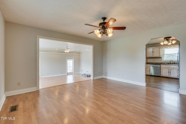 interior space featuring light hardwood / wood-style floors, ceiling fan, sink, and a textured ceiling