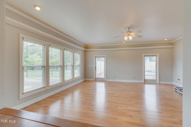 empty room featuring ornamental molding, light wood-type flooring, and ceiling fan