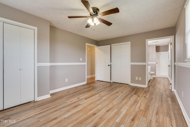 unfurnished bedroom featuring a textured ceiling, ensuite bath, light hardwood / wood-style flooring, and ceiling fan