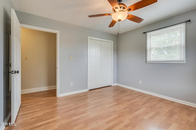 unfurnished bedroom with ceiling fan, light hardwood / wood-style flooring, and a closet