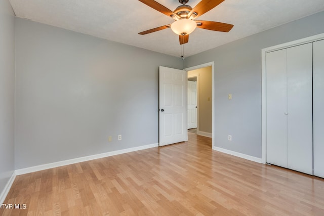 unfurnished bedroom featuring light hardwood / wood-style flooring, a closet, ceiling fan, and a textured ceiling