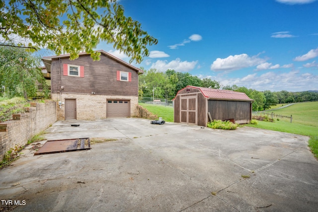 view of side of home featuring a lawn, a storage shed, and a garage