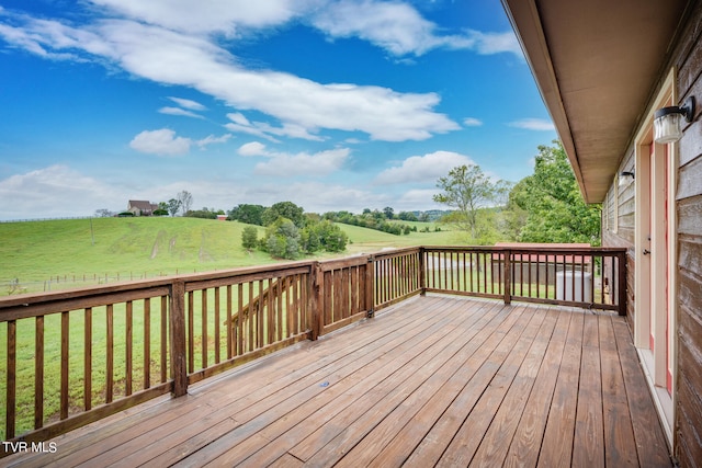 wooden deck with a lawn and a rural view