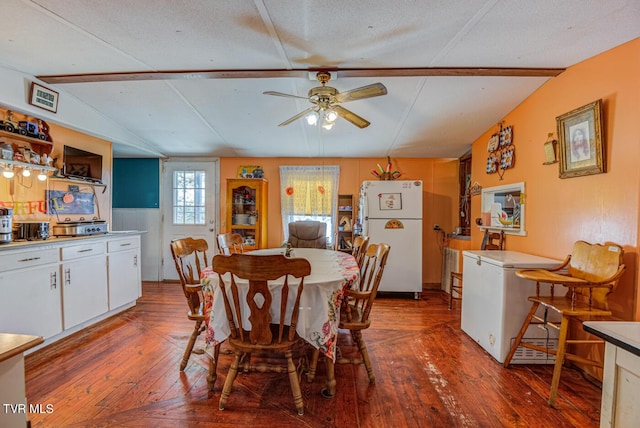 dining space featuring hardwood / wood-style floors, a textured ceiling, lofted ceiling with beams, and a ceiling fan