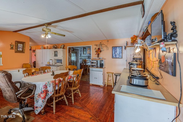 dining area featuring vaulted ceiling with beams, ceiling fan, and dark wood-style floors