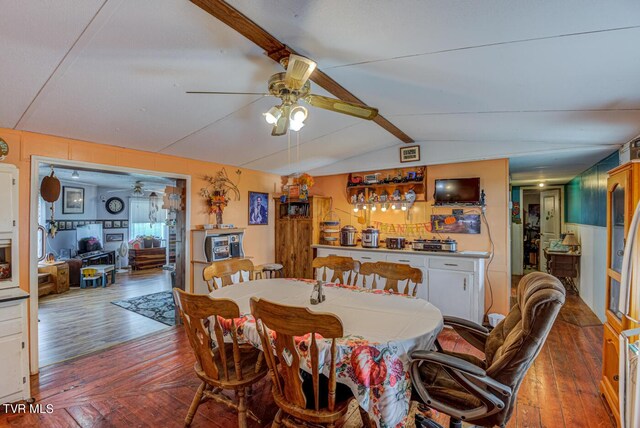 dining area with lofted ceiling, ceiling fan, hardwood / wood-style flooring, and bar area