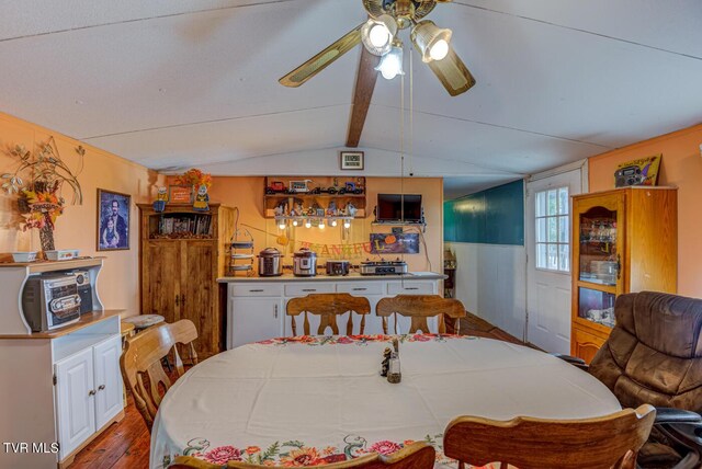 dining space with ceiling fan, vaulted ceiling with beams, and light hardwood / wood-style flooring