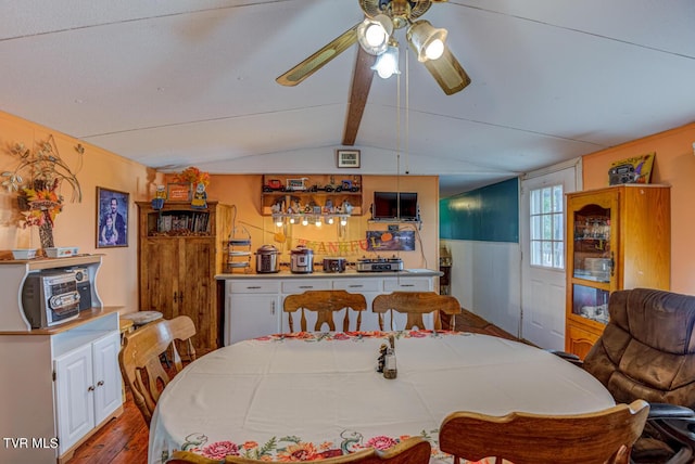 dining space with lofted ceiling with beams, ceiling fan, and wood finished floors