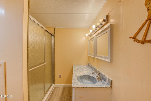 bathroom with vanity, a shower with shower door, and hardwood / wood-style flooring