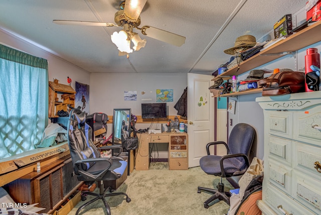 carpeted home office with ceiling fan and a textured ceiling