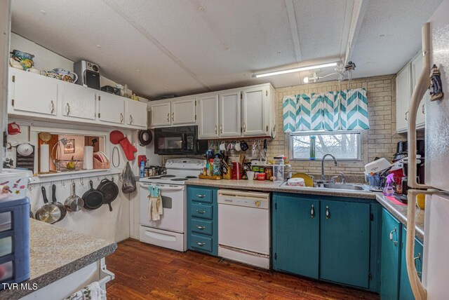 kitchen with blue cabinets, white cabinets, sink, white appliances, and dark wood-type flooring