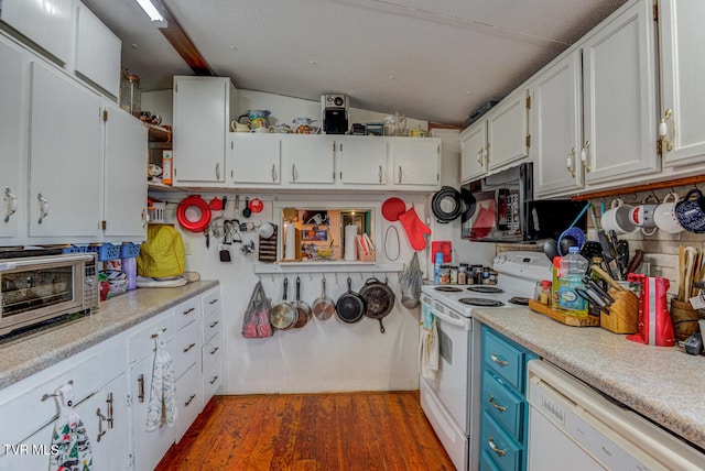 kitchen with lofted ceiling, white appliances, white cabinetry, and dark hardwood / wood-style flooring