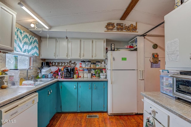 kitchen featuring visible vents, white appliances, wood finished floors, a sink, and vaulted ceiling with beams