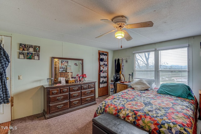 carpeted bedroom with ceiling fan and a textured ceiling