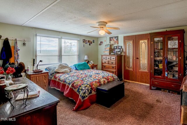 carpeted bedroom featuring a textured ceiling and ceiling fan