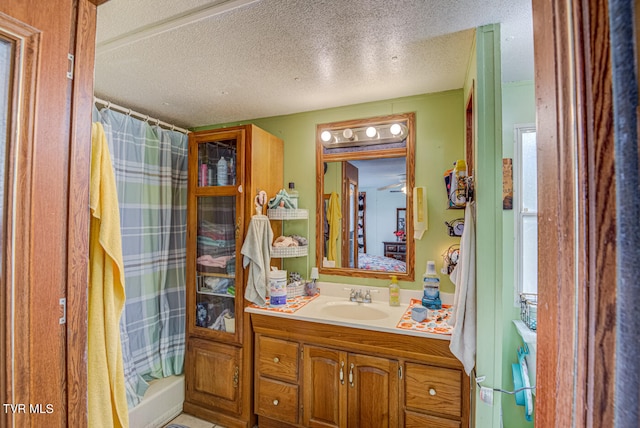 bathroom with a shower with shower curtain, a textured ceiling, and vanity