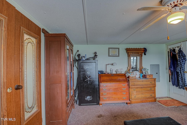 carpeted bedroom with a closet, a textured ceiling, ceiling fan, wooden walls, and electric panel