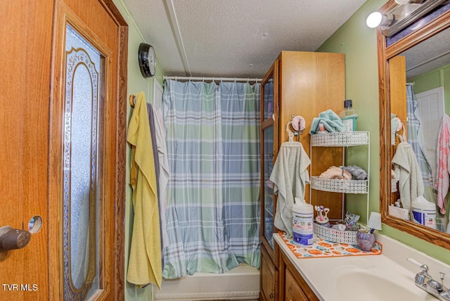 full bathroom with vanity, curtained shower, and a textured ceiling