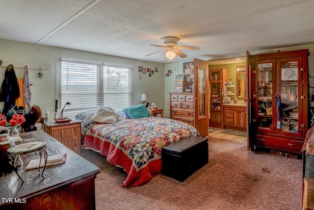 carpeted bedroom with connected bathroom, ceiling fan, and a textured ceiling