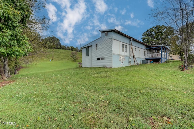 view of property exterior featuring central AC unit and a yard