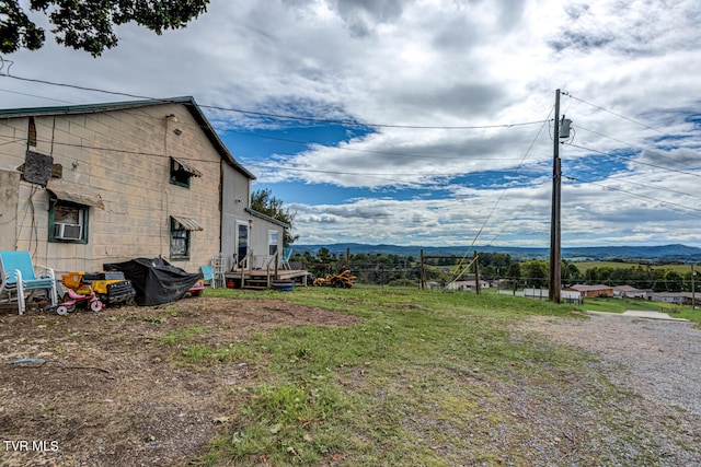 view of yard featuring cooling unit and a deck with mountain view