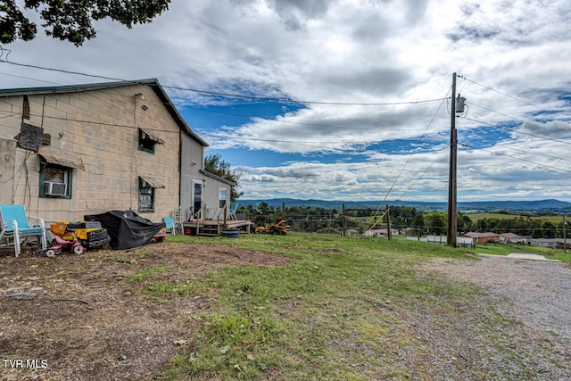 view of yard with cooling unit, a mountain view, and fence