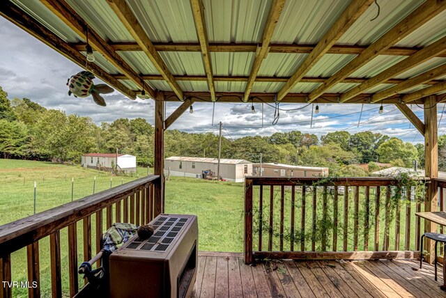 wooden deck with a yard and a storage unit