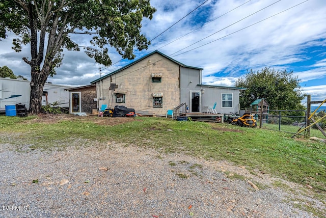 back of property featuring fence and a lawn