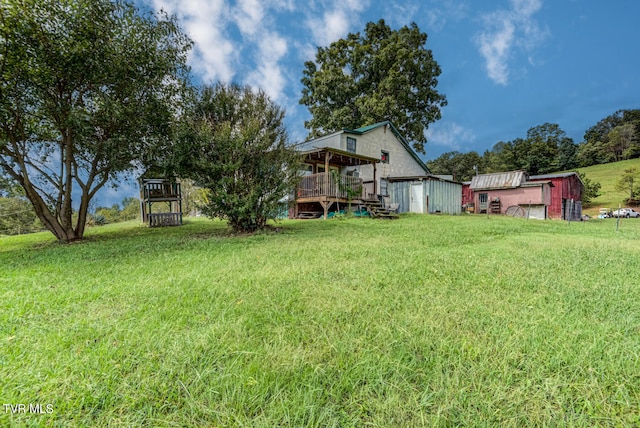 view of yard featuring a wooden deck and an outbuilding