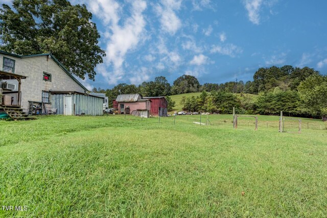 view of yard featuring a shed and a rural view