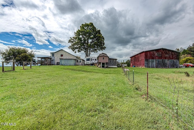 view of yard featuring an outbuilding, a barn, and fence