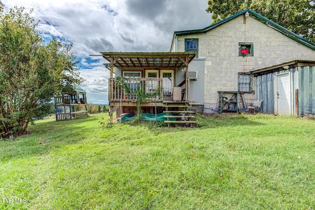rear view of property featuring a wall unit AC, a lawn, a wooden deck, and a pergola