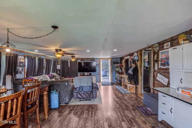 living room featuring a ceiling fan and dark wood-style floors