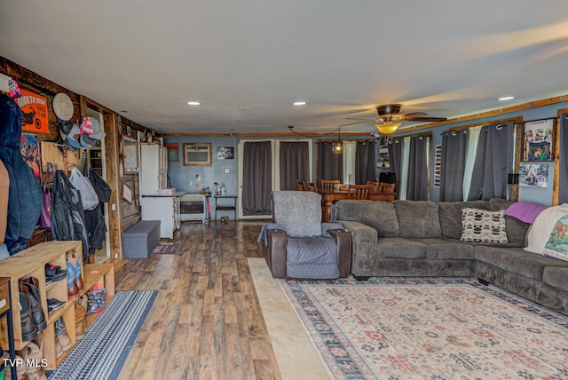 living room with a wall mounted AC, ceiling fan, and dark wood-type flooring