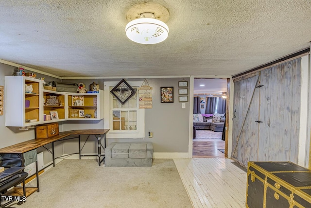 office area with baseboards, hardwood / wood-style flooring, and a textured ceiling