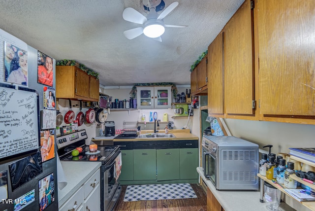 kitchen with ceiling fan, sink, a textured ceiling, stainless steel appliances, and dark hardwood / wood-style floors