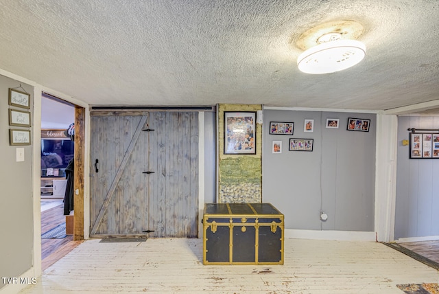 interior space with wood walls, a textured ceiling, and hardwood / wood-style flooring