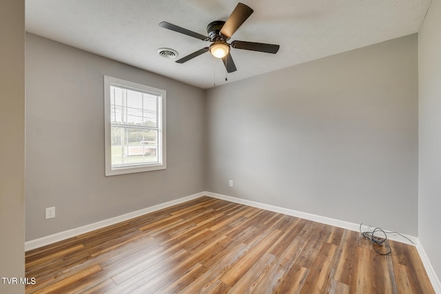 empty room with wood-type flooring, ceiling fan, and a textured ceiling