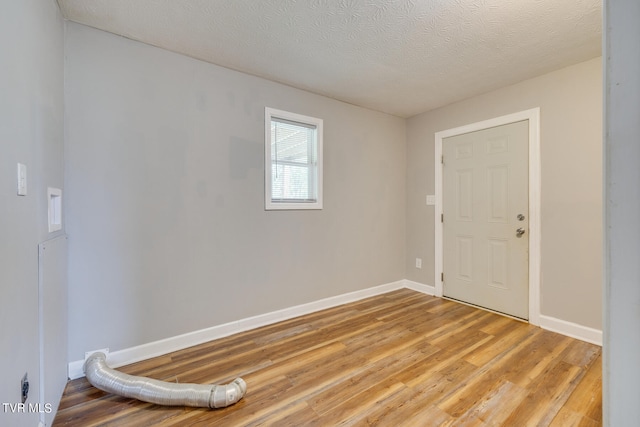 unfurnished room featuring a textured ceiling and hardwood / wood-style flooring