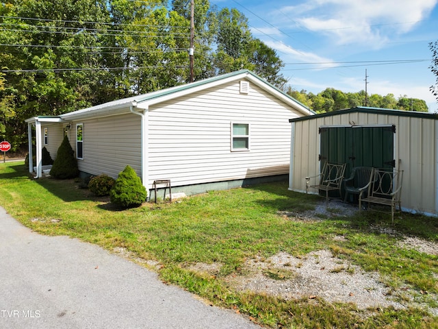 view of side of property featuring a storage unit and a lawn