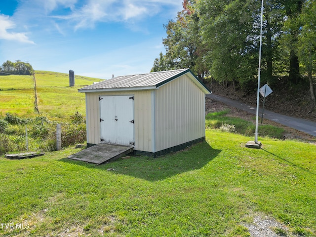 view of outdoor structure with a yard and a rural view