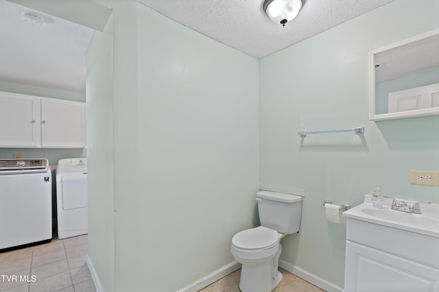 bathroom featuring washer and dryer, a textured ceiling, toilet, vanity, and tile patterned floors