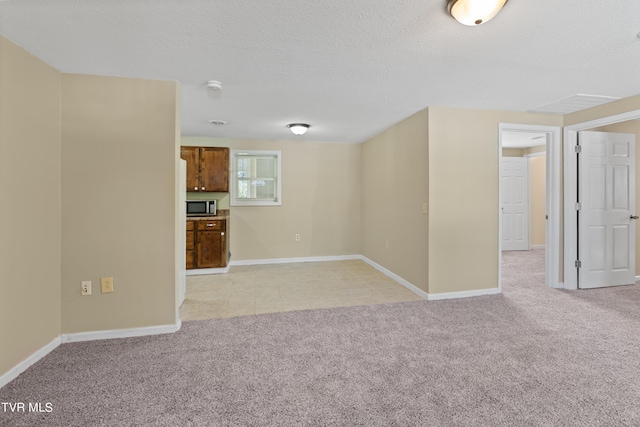 unfurnished living room featuring light carpet and a textured ceiling